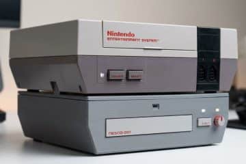 Le lecteur de disques NESCD avec une Nintendo NES posée dessus